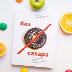 Top view of various fresh fruits and colorful magnet arranged on white background with book about proper nutrition